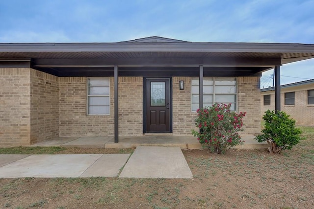 view of exterior entry featuring brick siding