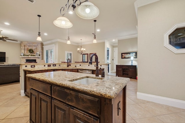 6407 Saddle Horn Ln, Midland, TX 79707 - kitchen with light tile patterned flooring, open floor plan, a kitchen island with sink, a fireplace, and crown molding