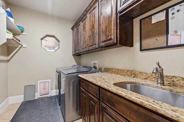 6407 Saddle Horn Ln, Midland, TX 79707 - laundry area featuring washer and dryer, cabinet space, light tile patterned floors, and baseboards