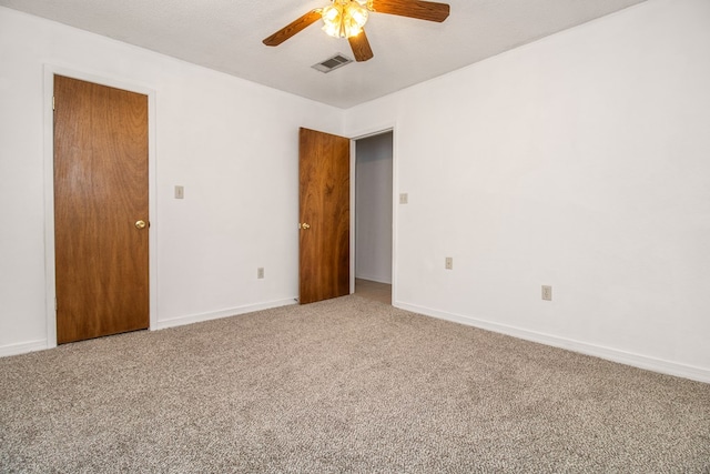 carpeted spare room featuring ceiling fan and a textured ceiling