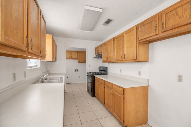 kitchen featuring sink, extractor fan, light tile patterned floors, a textured ceiling, and black range with gas stovetop