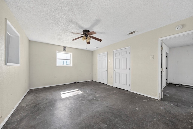 5408 E Loop 250e Unit A, Midland, TX 79705 - unfurnished bedroom featuring a textured ceiling, concrete flooring, ceiling fan, and two closets