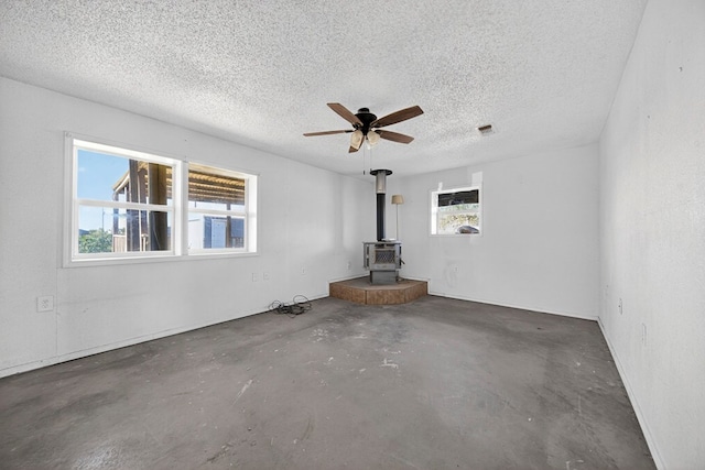 5408 E Loop 250e Unit A, Midland, TX 79705 - spare room with a wood stove, concrete floors, a ceiling fan, and a textured ceiling