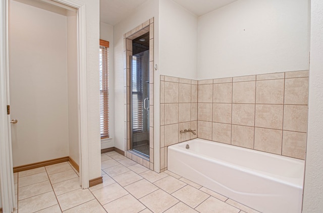 full bathroom featuring baseboards, tile patterned flooring, a shower stall, and a garden tub