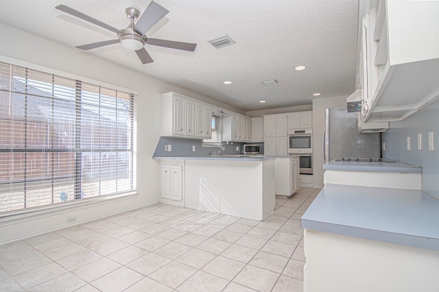 kitchen with visible vents, white cabinets, appliances with stainless steel finishes, and a wealth of natural light