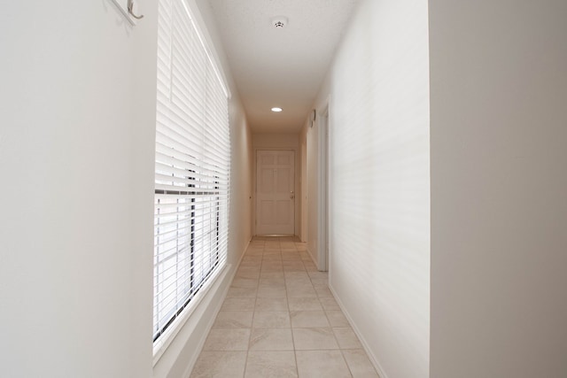 hall with recessed lighting and baseboards