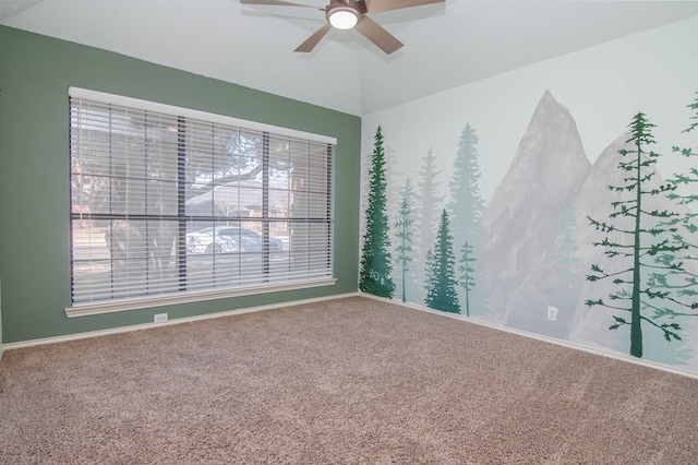 carpeted spare room with ceiling fan and baseboards