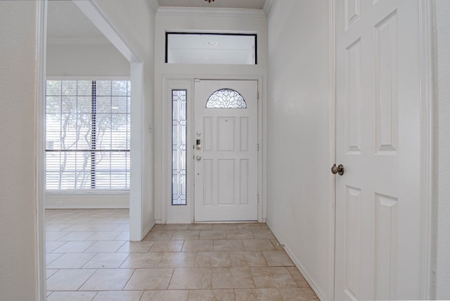 foyer entrance with crown molding, baseboards, and light tile patterned floors
