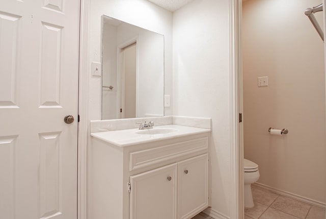 bathroom featuring tile patterned floors, baseboards, vanity, and toilet
