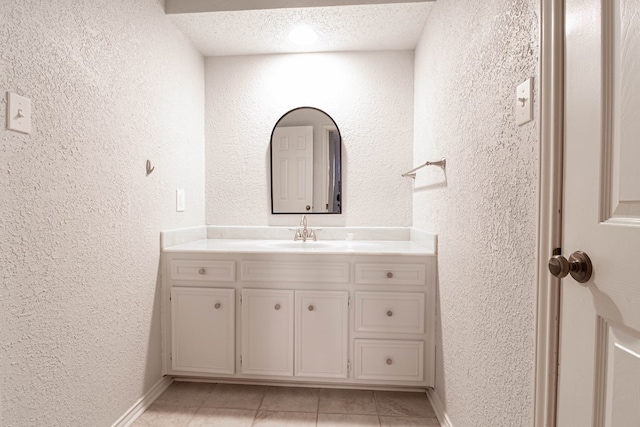 bathroom featuring tile patterned flooring and a textured wall