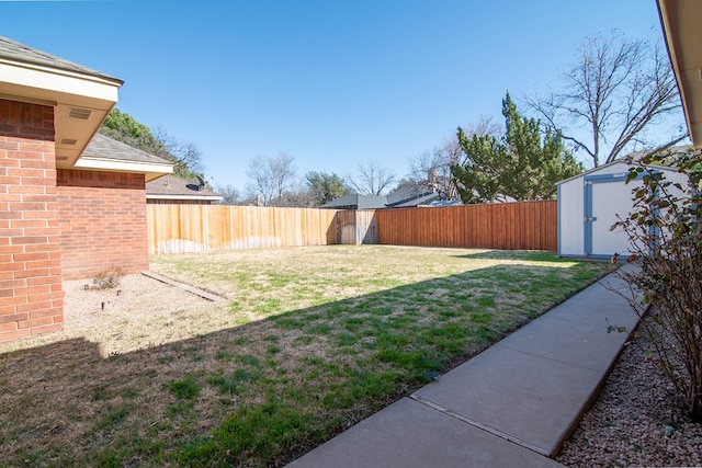 view of yard with a storage shed, an outdoor structure, and a fenced backyard