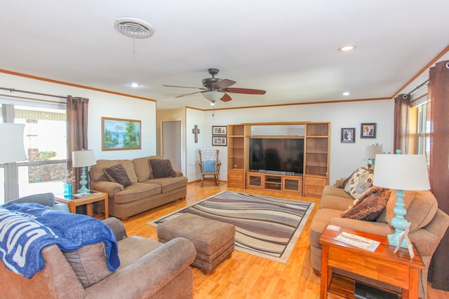 living room featuring ornamental molding, a healthy amount of sunlight, and wood-type flooring