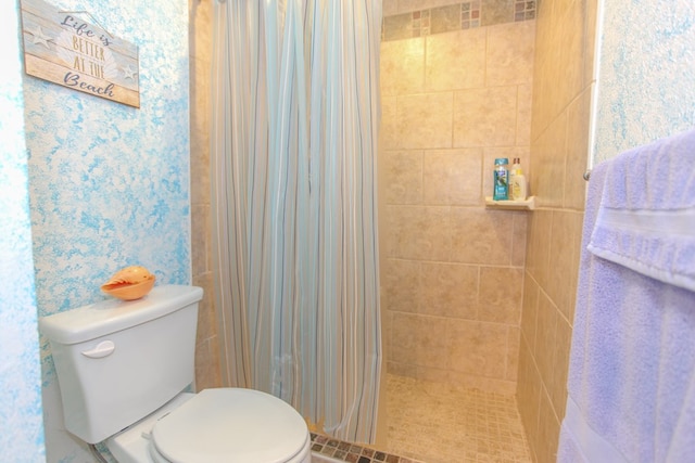 bathroom featuring toilet and a tile shower