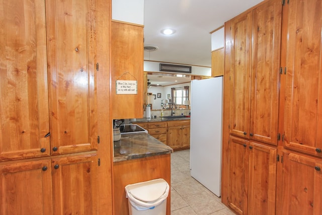 kitchen featuring sink, light tile patterned flooring, black electric stovetop, and white refrigerator