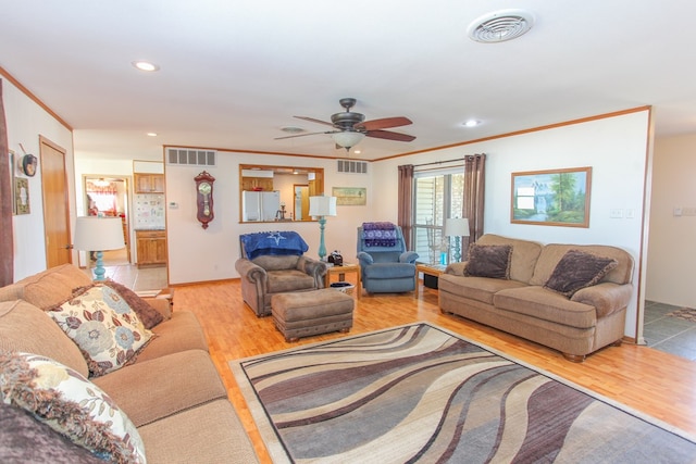 living room featuring crown molding, ceiling fan, and light hardwood / wood-style flooring