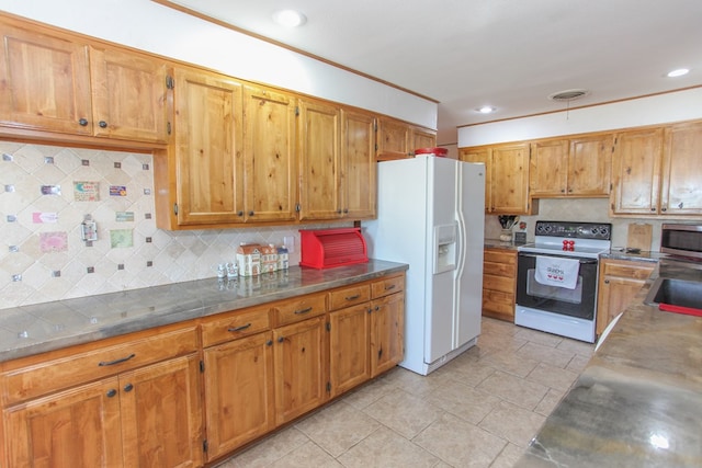 kitchen with white refrigerator with ice dispenser, electric range oven, sink, and backsplash