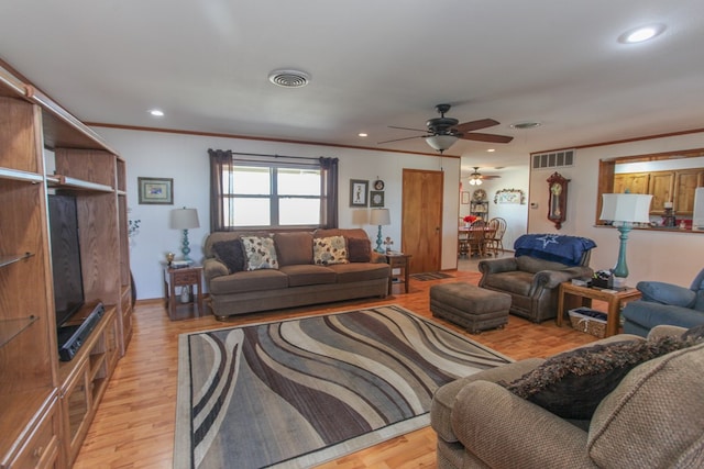 living room with ornamental molding, light hardwood / wood-style floors, and ceiling fan