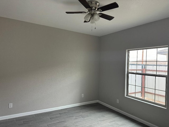 spare room with ceiling fan, a healthy amount of sunlight, and wood-type flooring