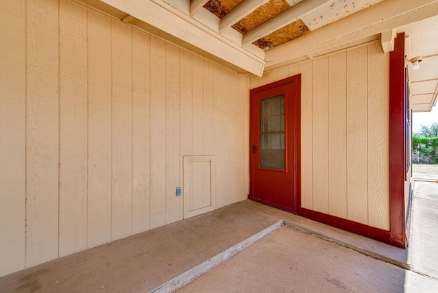 view of exterior entry with a patio area