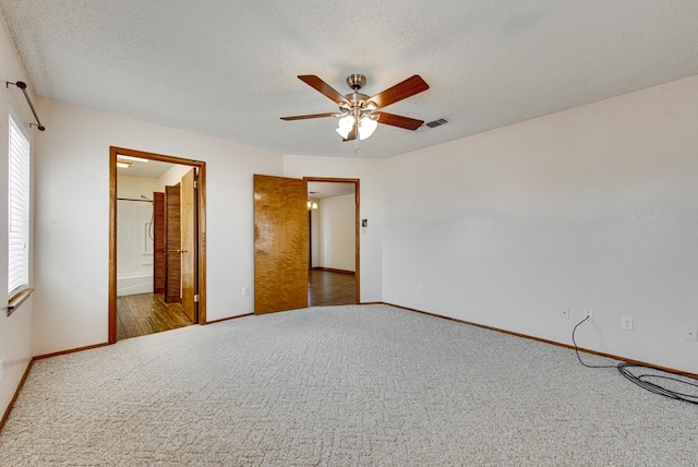 4600 S County Rd 1185, Midland, TX 79706 - unfurnished bedroom featuring a textured ceiling, visible vents, baseboards, carpet, and ensuite bath