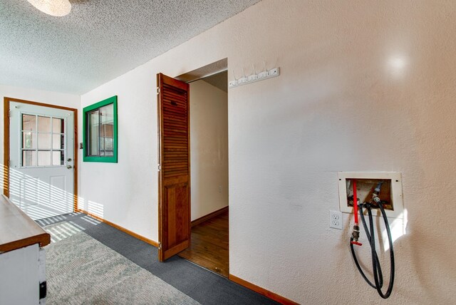 interior space featuring baseboards, a textured ceiling, and a textured wall