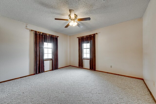 carpeted spare room featuring baseboards, a textured ceiling, and a ceiling fan