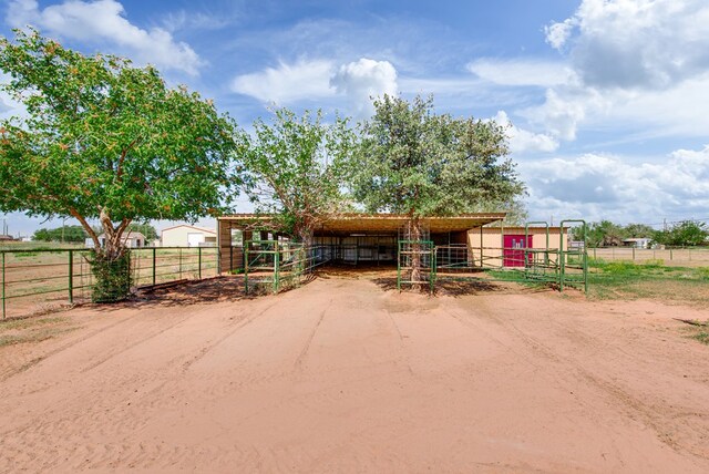 view of front facade featuring an exterior structure, an outbuilding, and a rural view