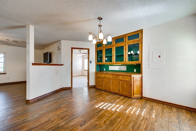 kitchen with electric panel, pendant lighting, a textured ceiling, and wood-type flooring