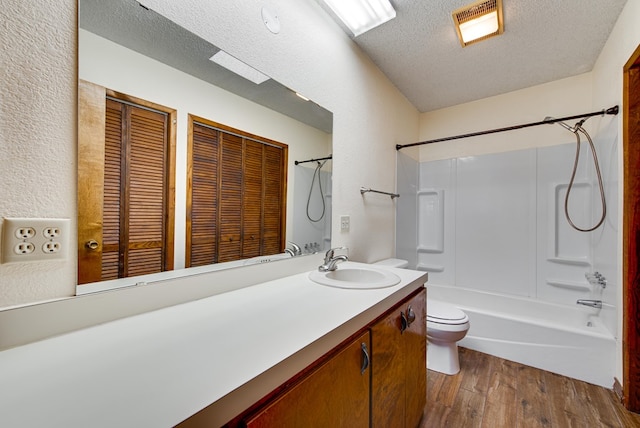 4600 S County Rd 1185, Midland, TX 79706 - bathroom featuring shower / tub combination, vanity, toilet, a textured ceiling, and wood finished floors