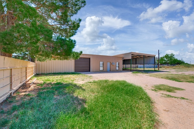 4600 S County Rd 1185, Midland, TX 79706 - view of yard featuring dirt driveway, an outbuilding, a garage, fence, and an outdoor structure