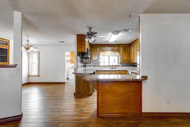 kitchen featuring kitchen peninsula, ceiling fan, hardwood / wood-style floors, and a healthy amount of sunlight