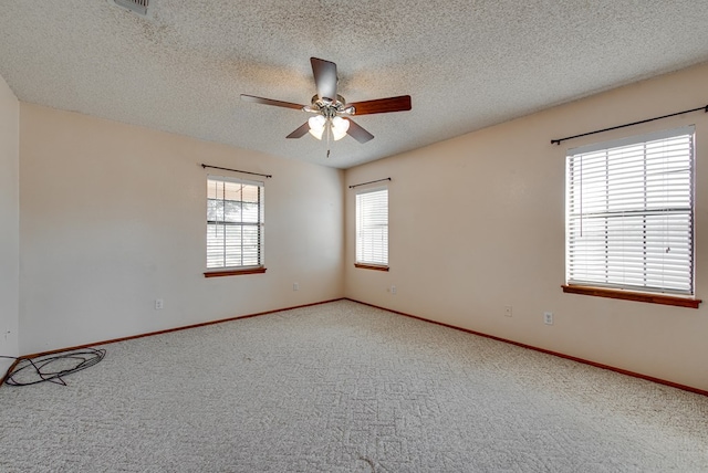 carpeted spare room featuring ceiling fan, a healthy amount of sunlight, and a textured ceiling