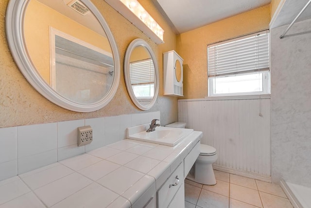 4902 Leisure Dr, Midland, TX 79703 - bathroom with vanity, a shower, tile patterned floors, and wainscoting
