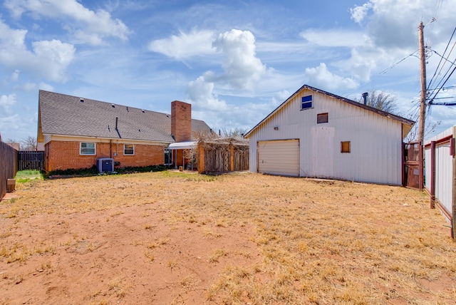 4902 Leisure Dr, Midland, TX 79703 - back of house featuring a detached garage, an outdoor structure, a chimney, and brick siding
