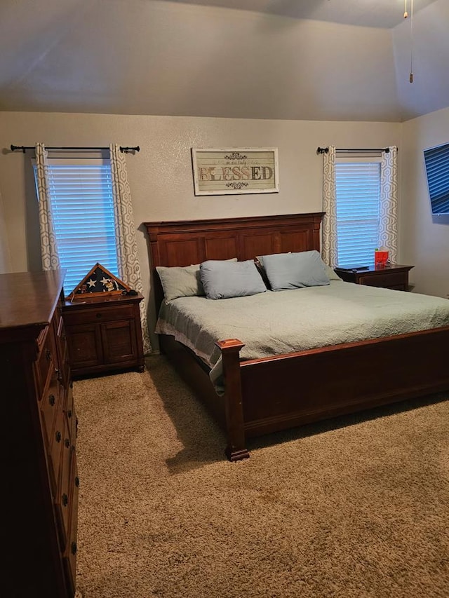 carpeted bedroom featuring ceiling fan and vaulted ceiling