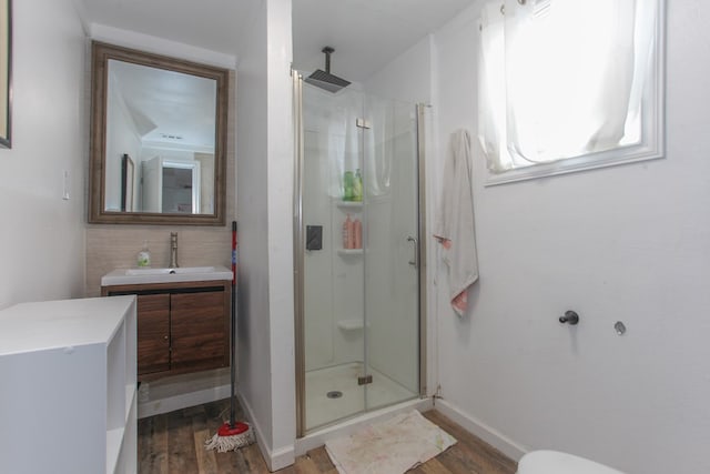 full bath with baseboards, tasteful backsplash, wood finished floors, and a shower stall