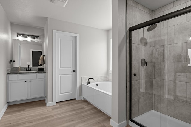 2906 Yellowstone Ct, Midland, TX 79705 - full bath with a garden tub, a stall shower, vanity, and wood finished floors