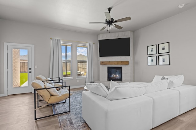 2906 Yellowstone Ct, Midland, TX 79705 - living area featuring light wood-type flooring, ceiling fan, a brick fireplace, and baseboards