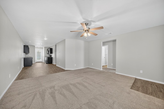 1317 Masquerade Blvd, Odessa, TX 79765 - unfurnished living room with ceiling fan, carpet, and wood finished floors