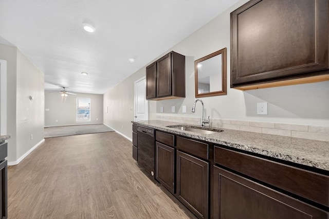 1317 Masquerade Blvd, Odessa, TX 79765 - kitchen featuring black dishwasher, light wood-style floors, dark brown cabinetry, ceiling fan, and light stone counters
