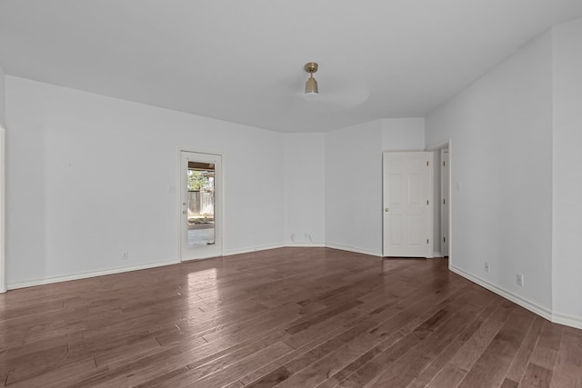 unfurnished room with baseboards and wood finished floors