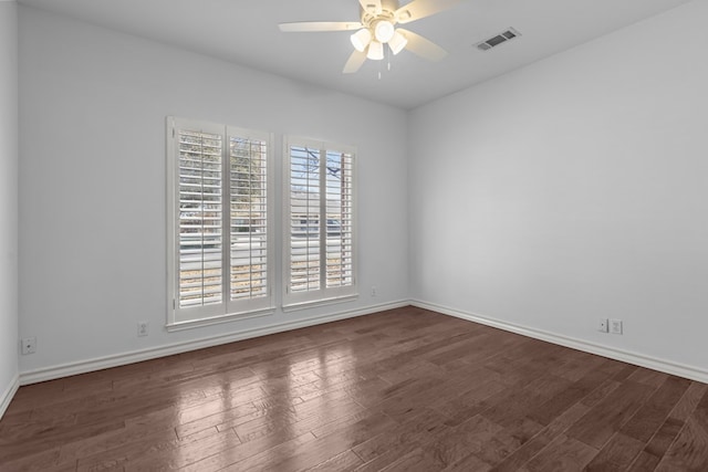 spare room featuring ceiling fan, wood finished floors, visible vents, and baseboards