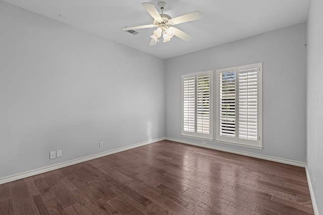 spare room with ceiling fan, wood finished floors, visible vents, and baseboards