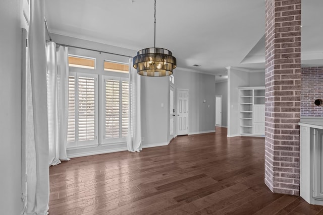 unfurnished dining area with baseboards, ornamental molding, a chandelier, and dark wood-style flooring