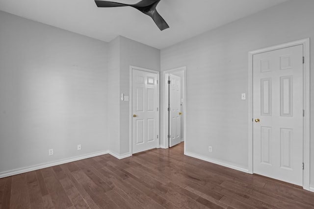 unfurnished bedroom featuring a ceiling fan, dark wood finished floors, and baseboards