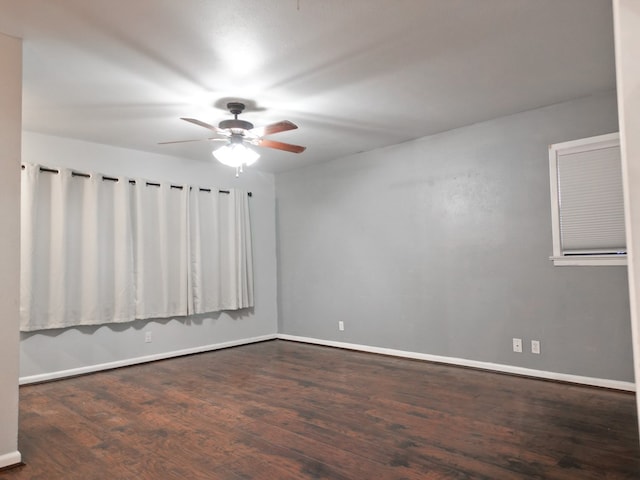 empty room with dark hardwood / wood-style flooring and ceiling fan