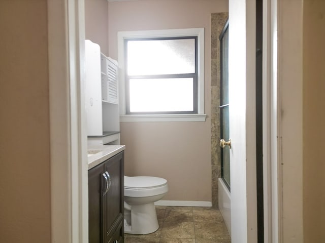 full bathroom featuring enclosed tub / shower combo, vanity, and toilet