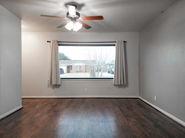 spare room featuring dark wood-type flooring and ceiling fan