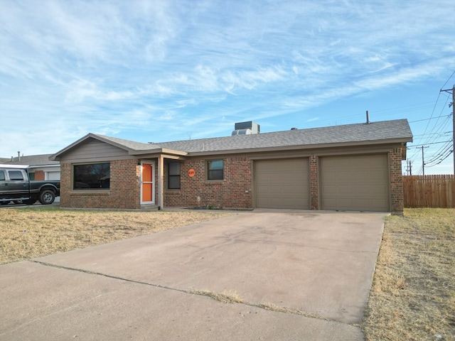 ranch-style home featuring a garage and cooling unit