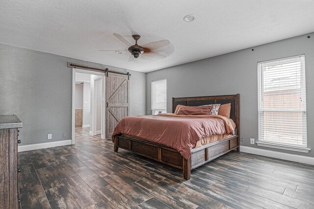 4404 Westminister Dr, Midland, TX 79707 - bedroom with wood finished floors, a barn door, baseboards, and multiple windows